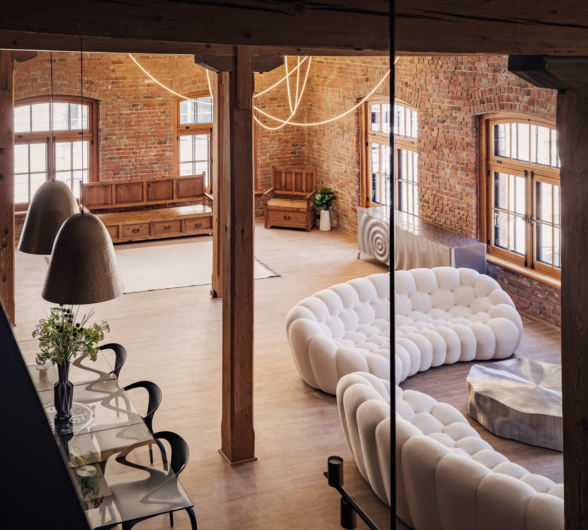 Wellington Loft — Exposed brick living area with tufted sofa